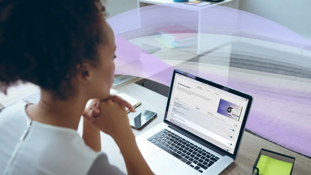 A woman is using GenAI Video PowerPack on her laptop in her office.