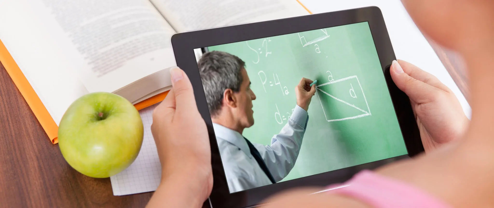 Female using tablet with chalkboard screen for educational use.