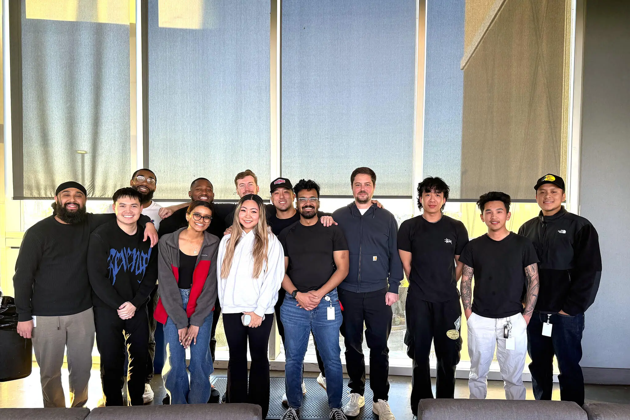 A group of YuJa team members standing together in an office, showcasing collaboration and teamwork in a professional setting.