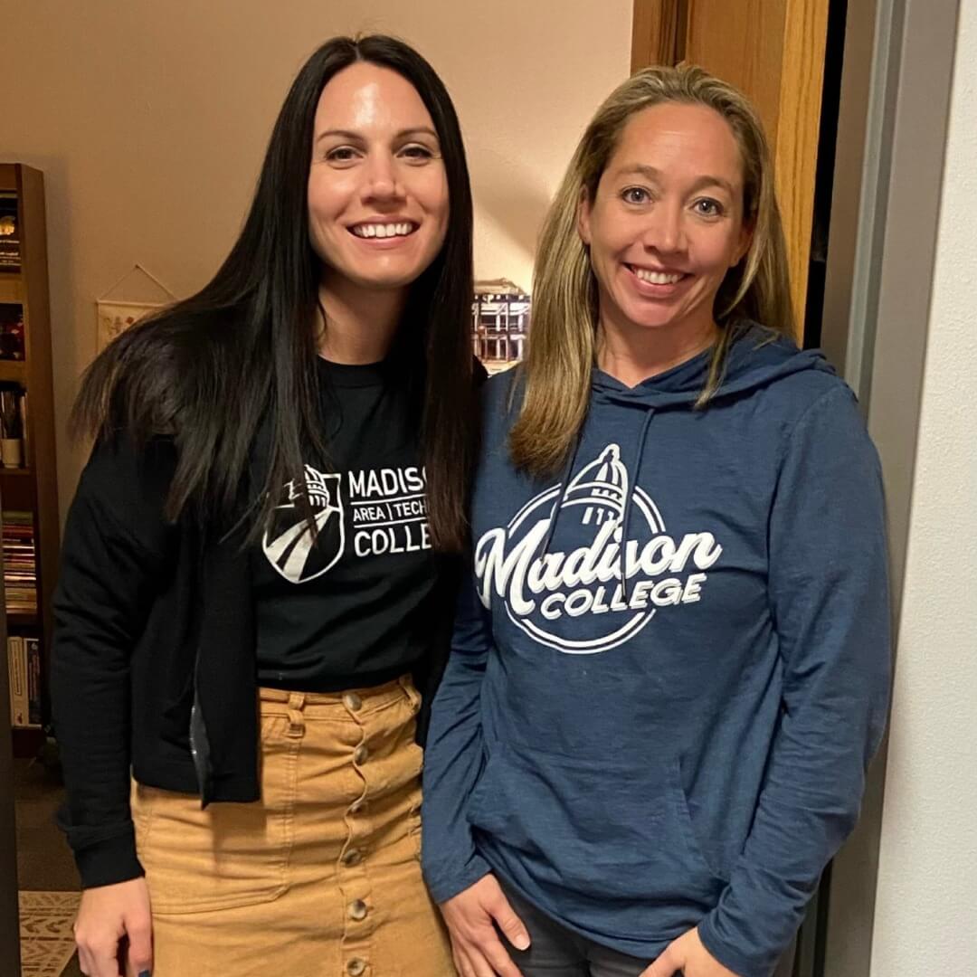 Two women standing next to each other in a room at Madison Area Technical College.