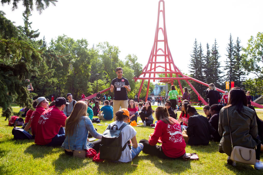 A group of University of Calgary students sitting on the grass.