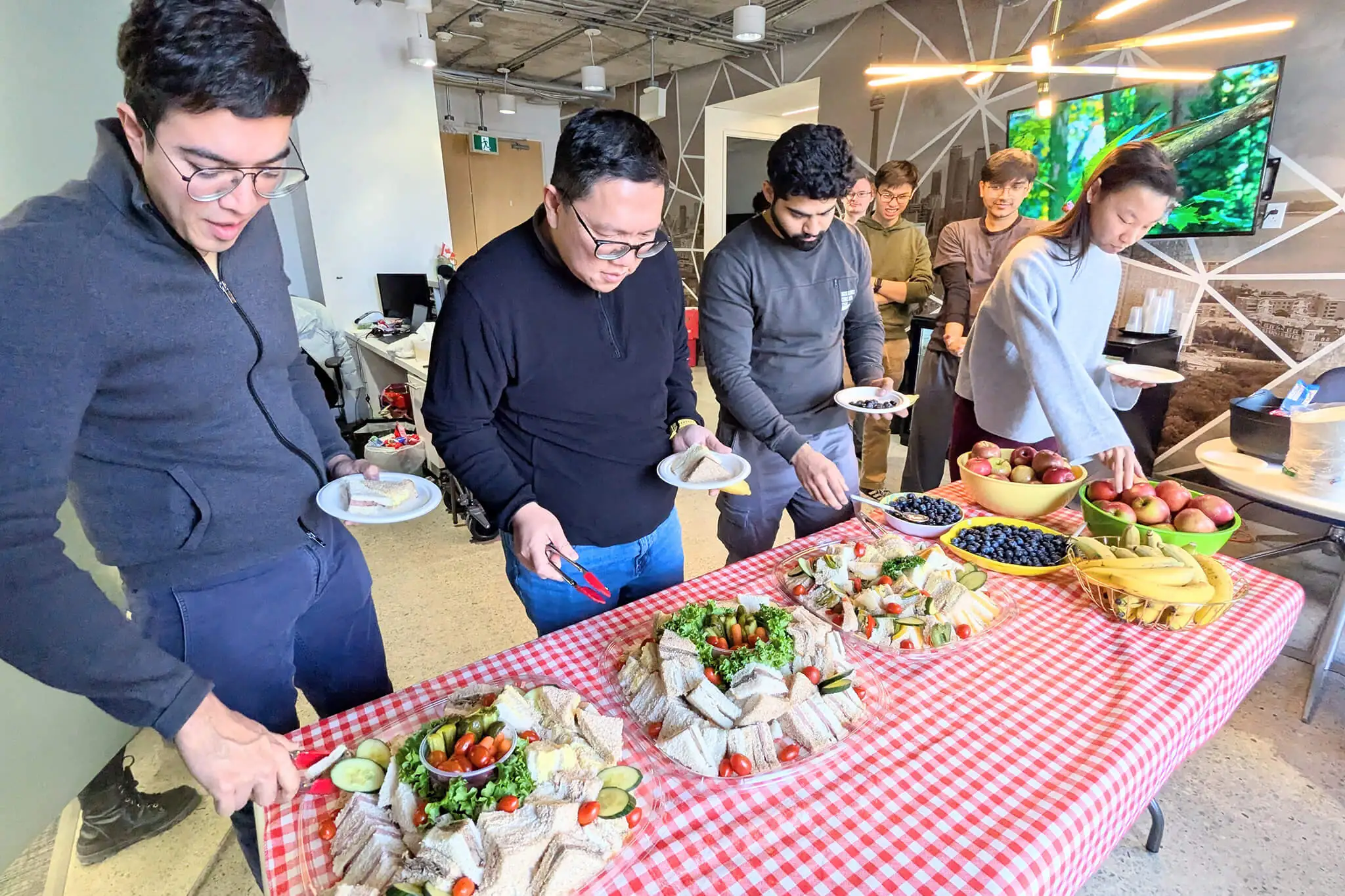 Members of YuJa's team enjoying a meal together at a table, sharing food and conversation.
