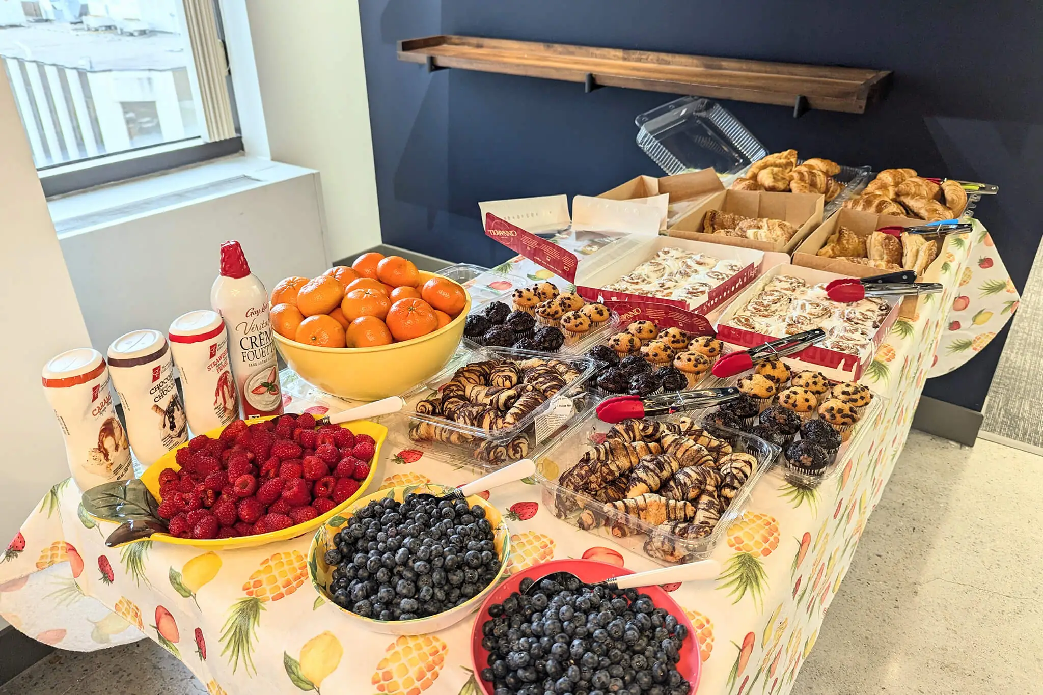 A beautifully arranged table featuring a variety of colorful fruits and an assortment of nuts, showcasing a healthy spread.