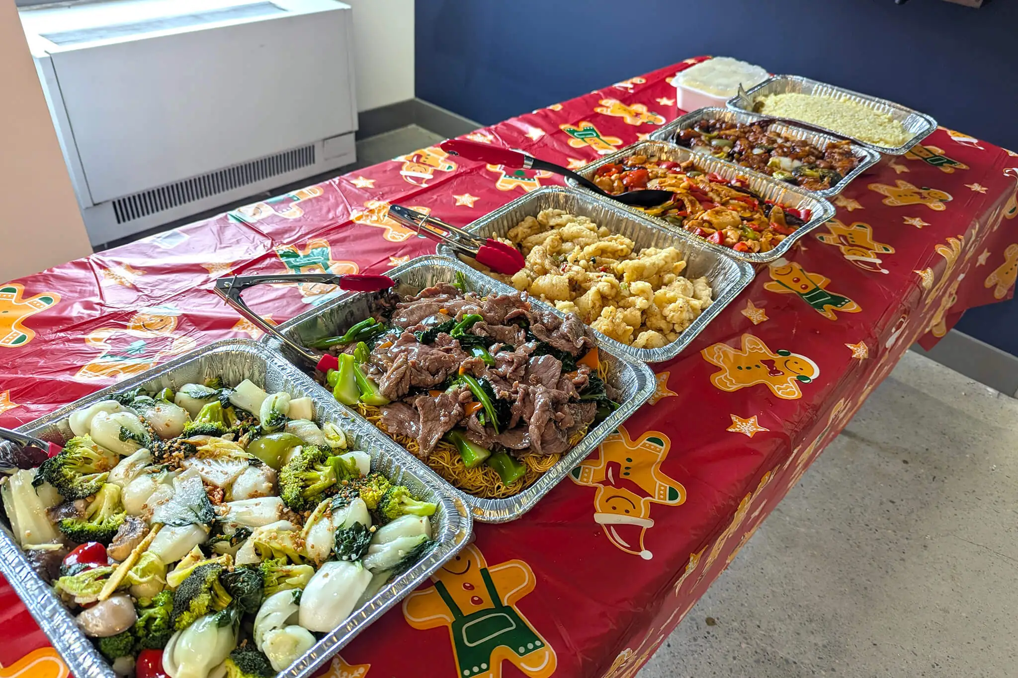 A table displaying multiple trays filled with a variety of food items, showcasing an inviting spread for guests.