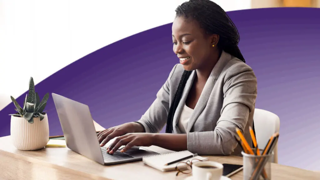 Female employee using laptop at workplace in office.