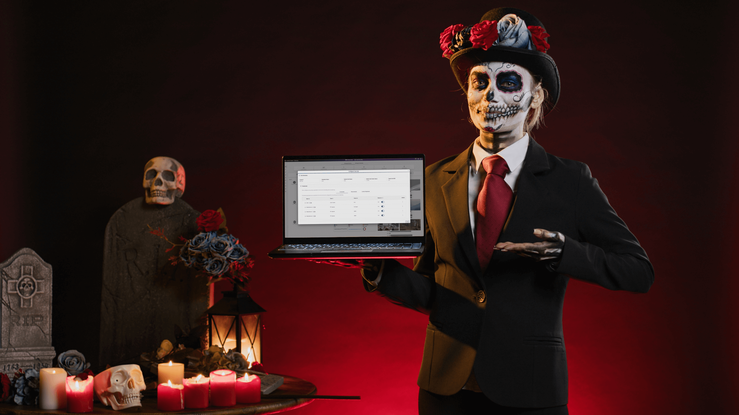 A woman in a Halloween costume in a spooky setting holds a laptop featuring the ability to configured peripheral devices when using Software Capture.