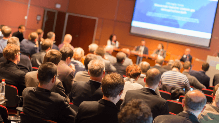 A crowd engaged in a panel of experts speaking