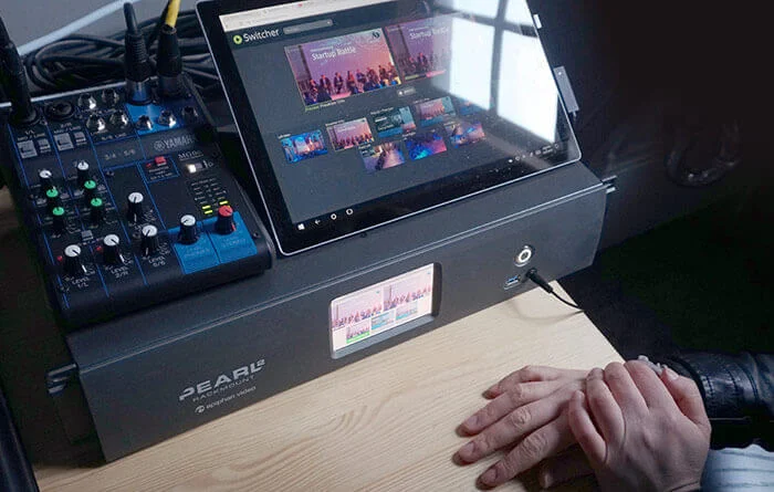 A person multitasking with a tablet computer and a mixer