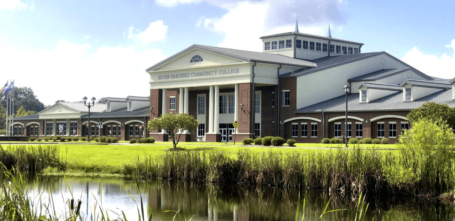 A River Parishes Community College building with a lake in front.