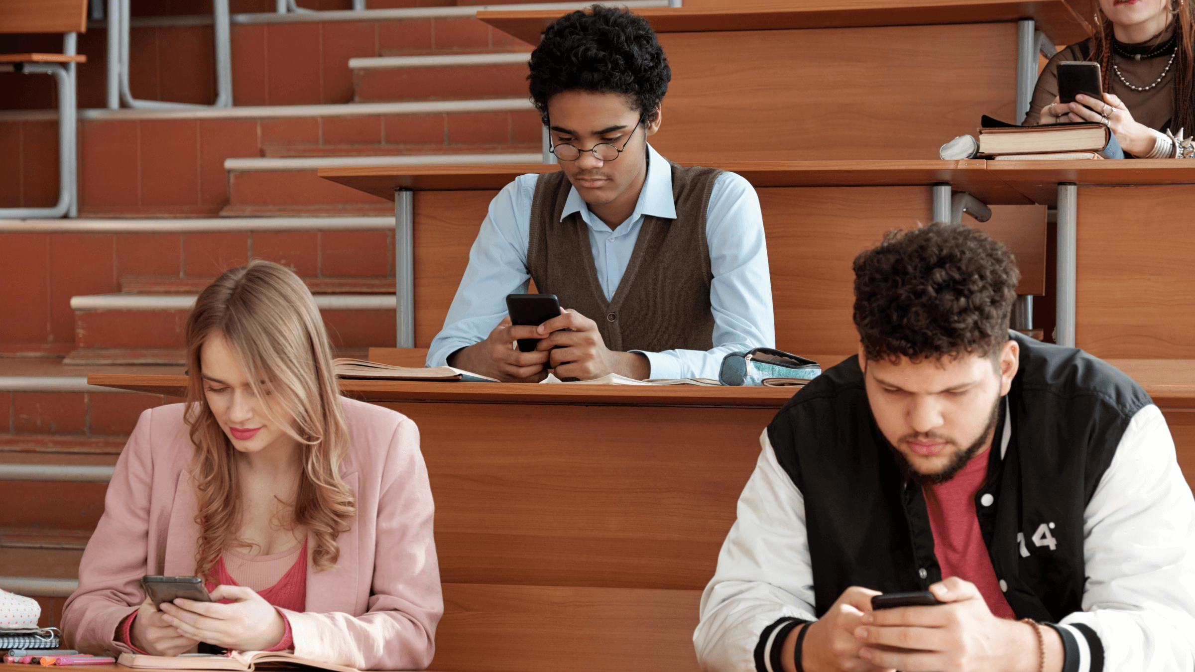 A group of students on their phones in a university lecture.