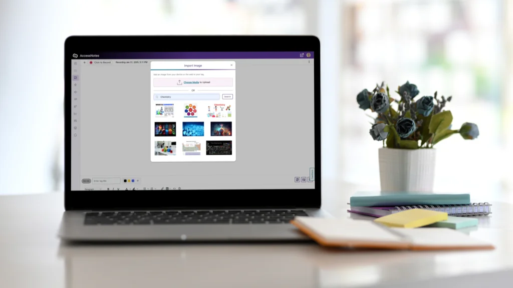 A computer sitting on a desk next to a small plant and notebook features YuJa AccessNotes on the screen.