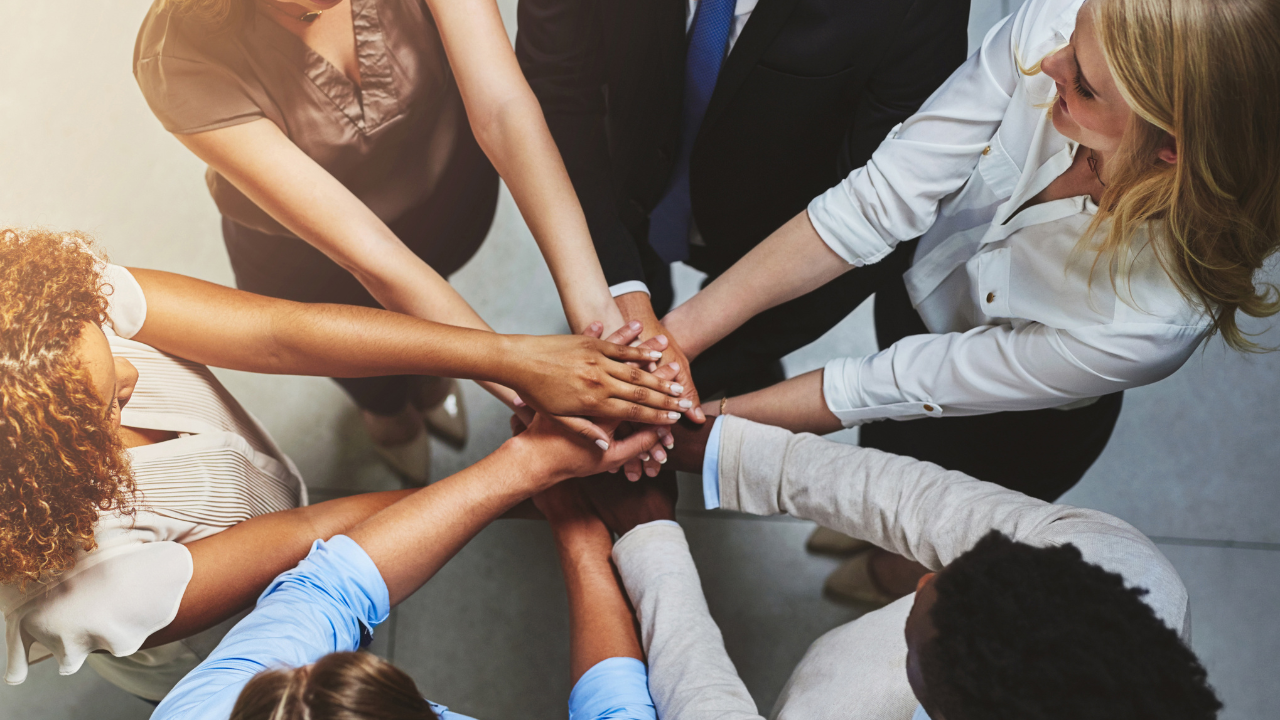 A group of students with their hands stacked together.