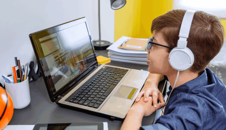 a student is watching a school lesson on a laptop