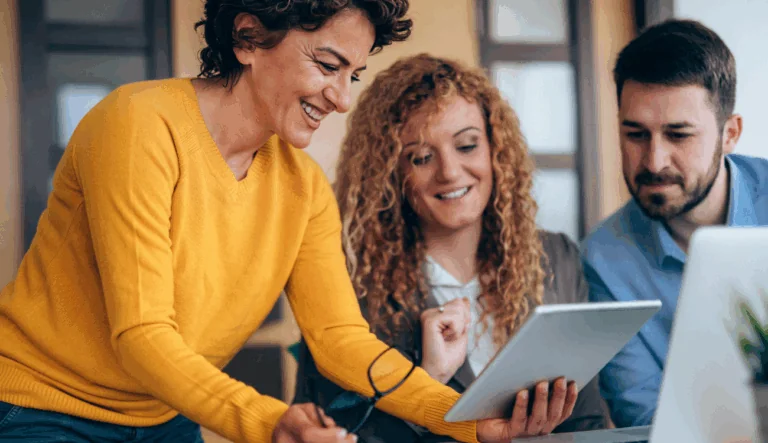 Three business professionals looking at a tablet