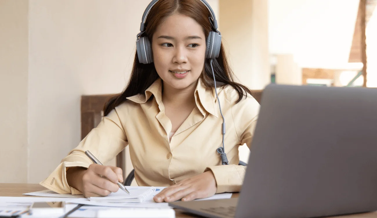 A young lady attends an online conference on her laptop.