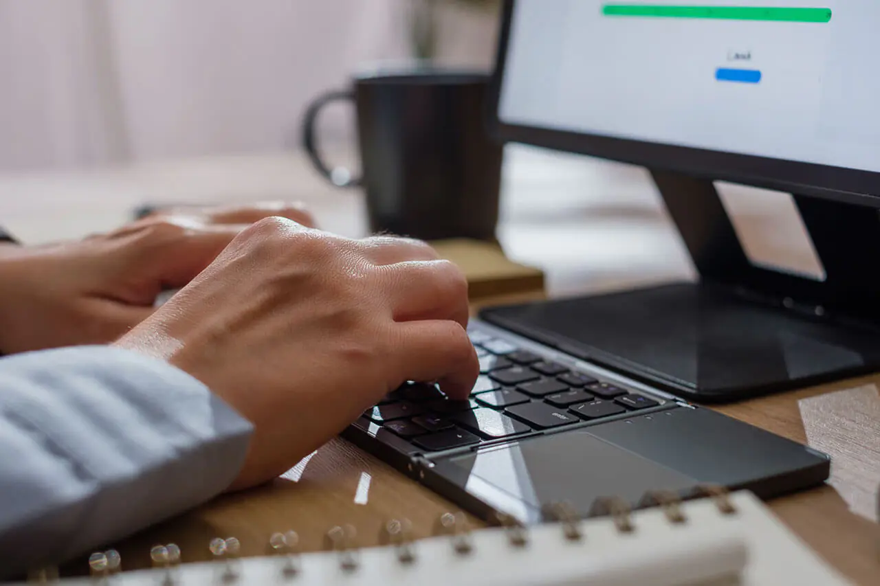 Close up of a person typing on a keyboard.