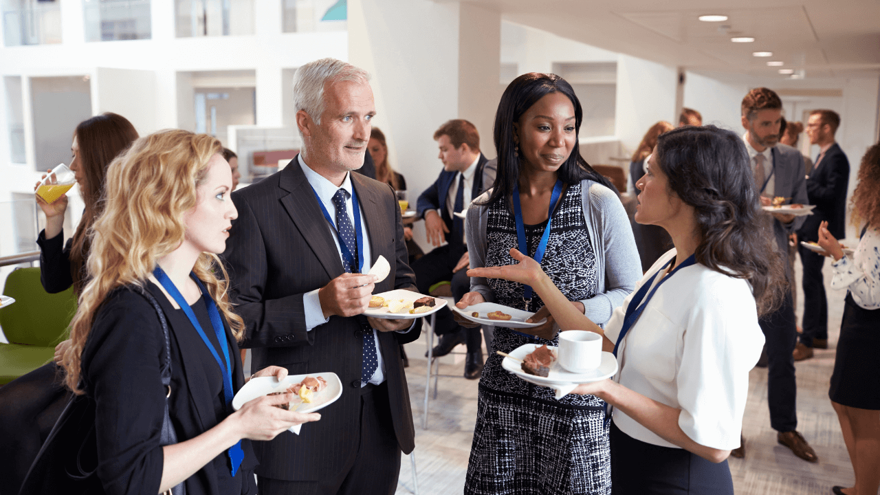 A group of professionals in a semicircle speak to one another.