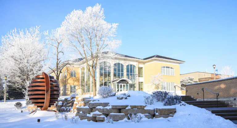 An Upper Iowa State building during the winter under a clear blue sky.