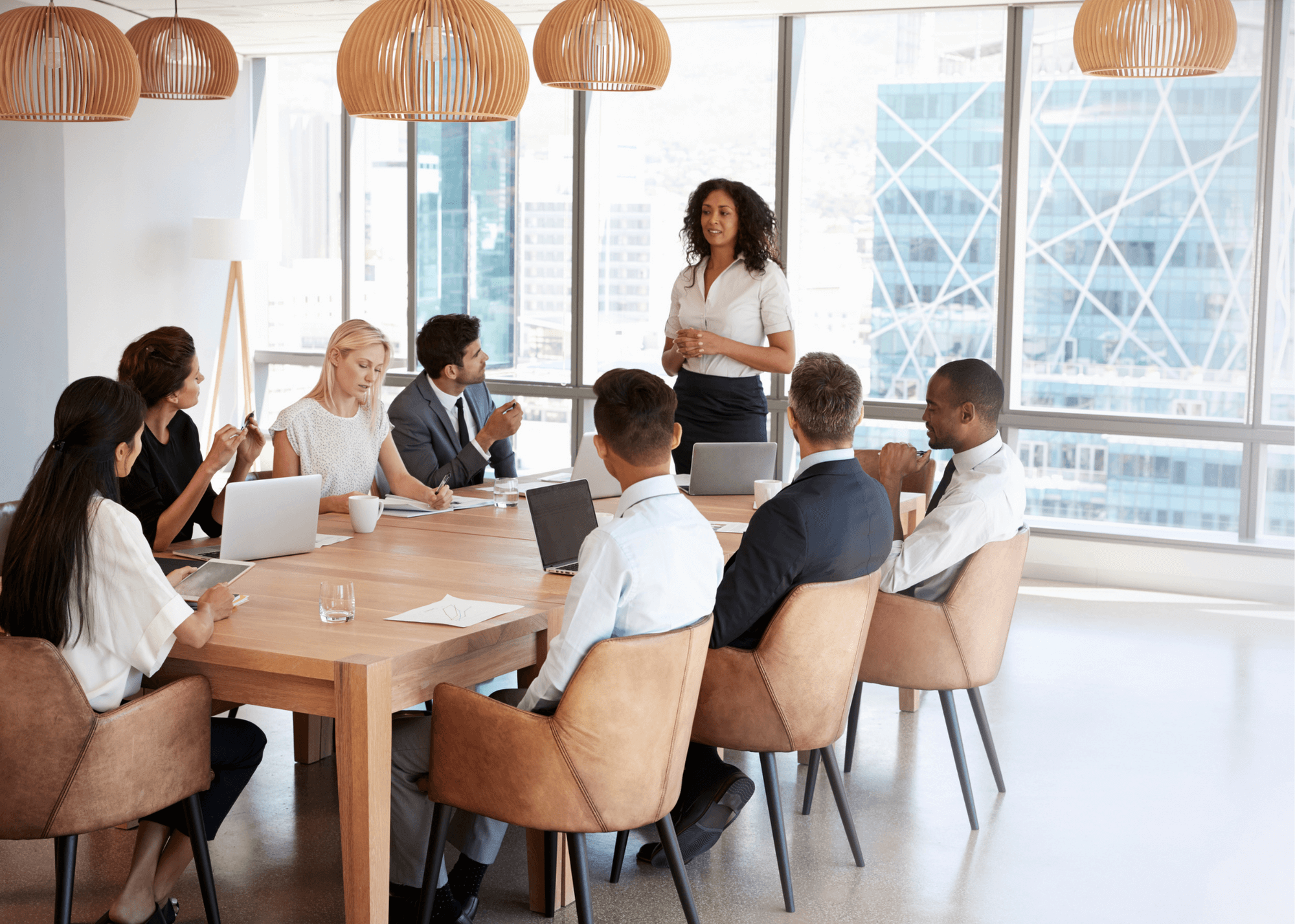 Executives sitting around a modern boardroom table.