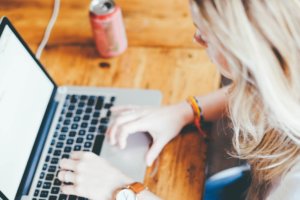 Woman typing on a laptop.