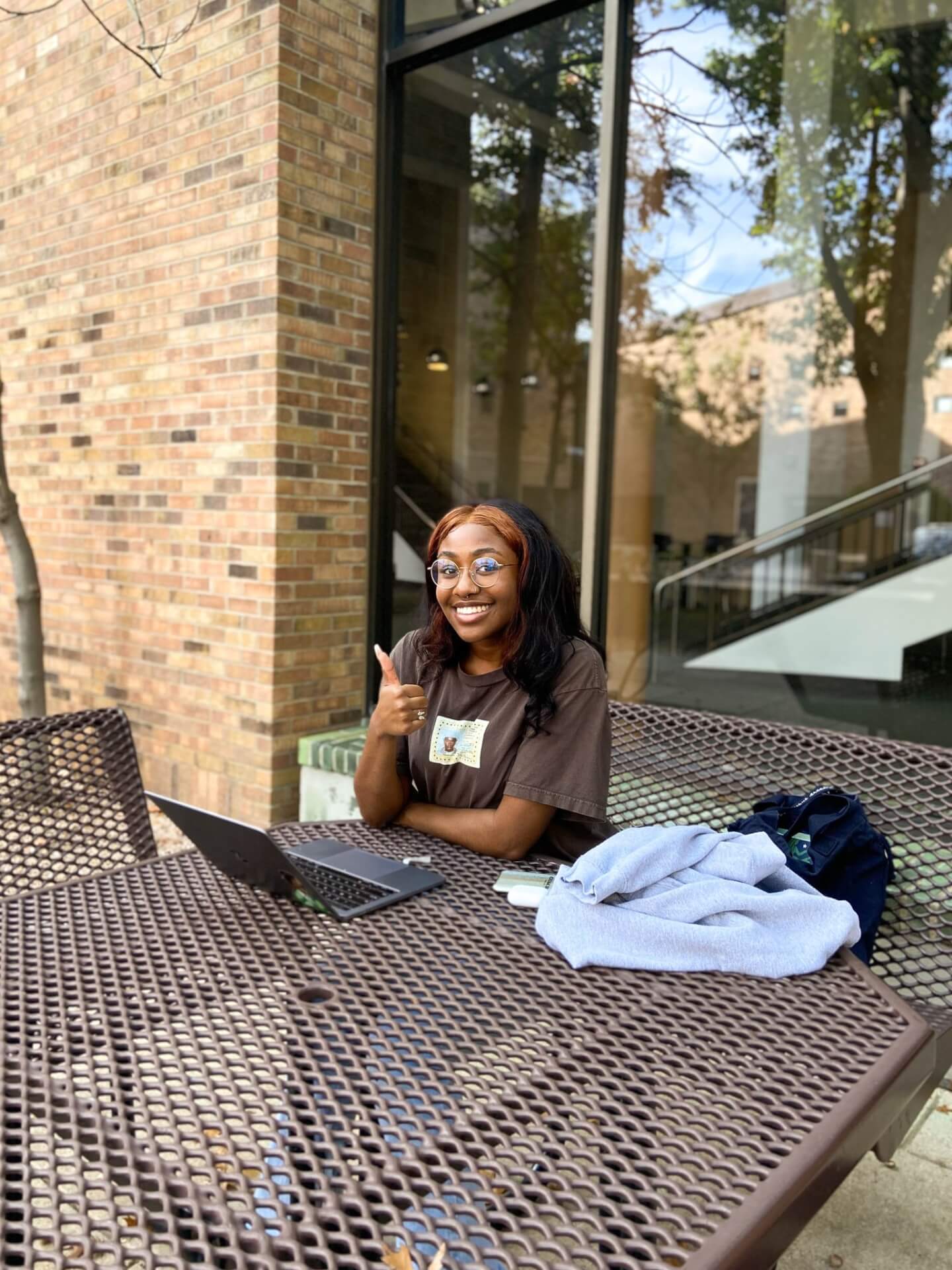 A woman sitting at a table with a laptop at Dallas College.