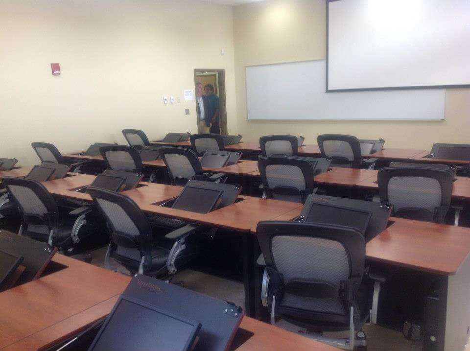 A classroom with neatly arranged desks and chairs.