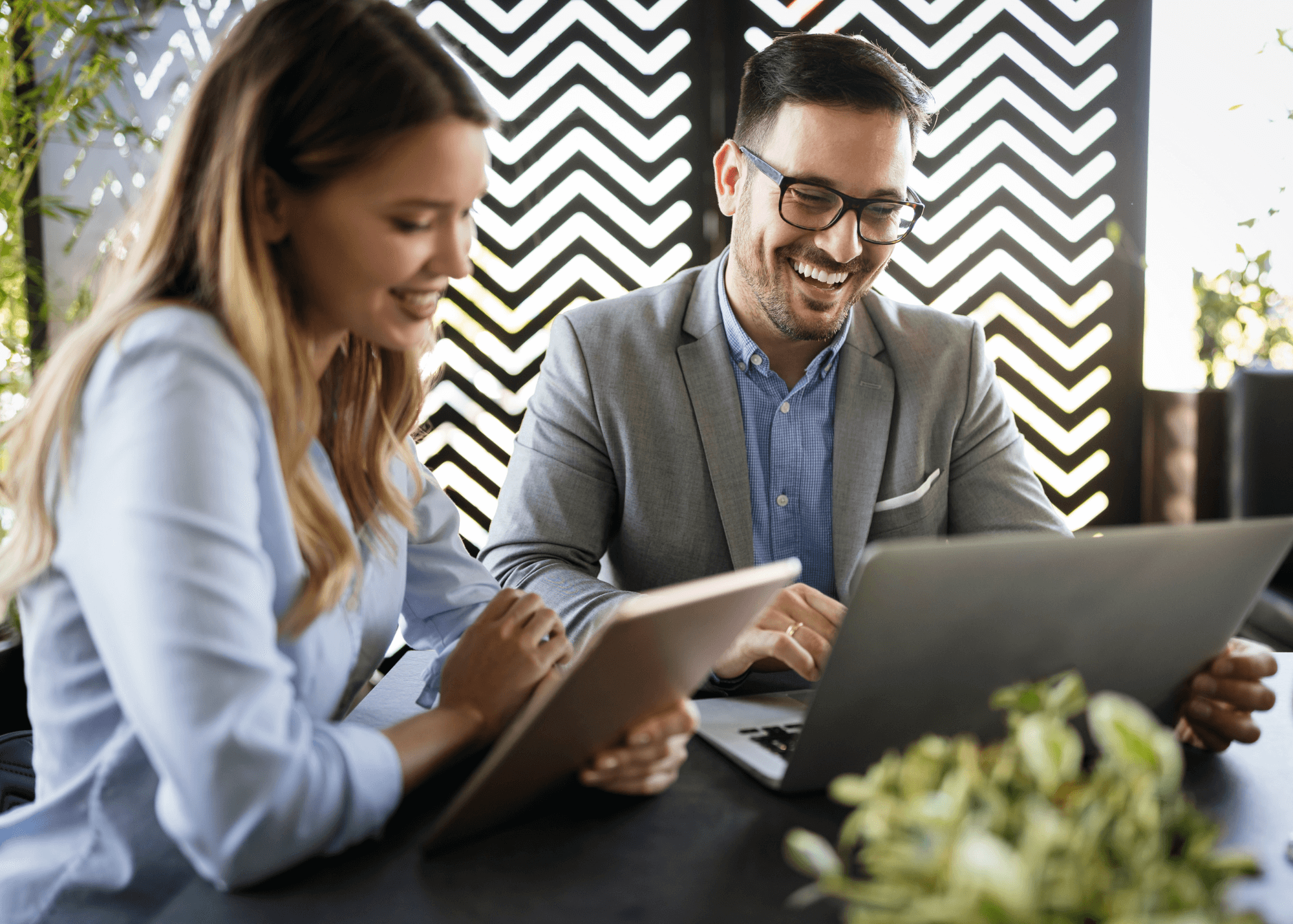 A man and woman look at a laptop together. 