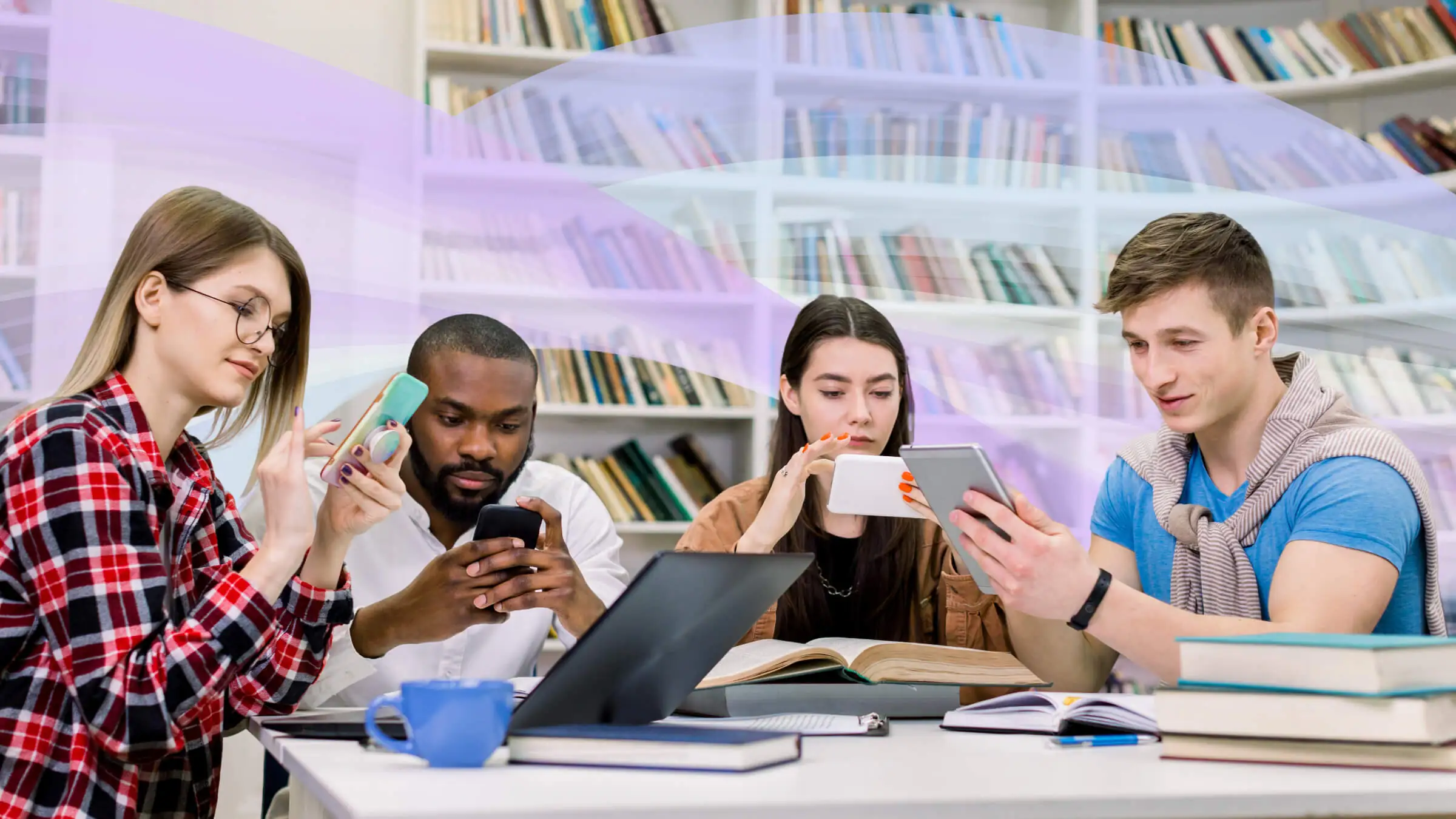 A group of college students sitting together at a desk in a library and using their smart devices.