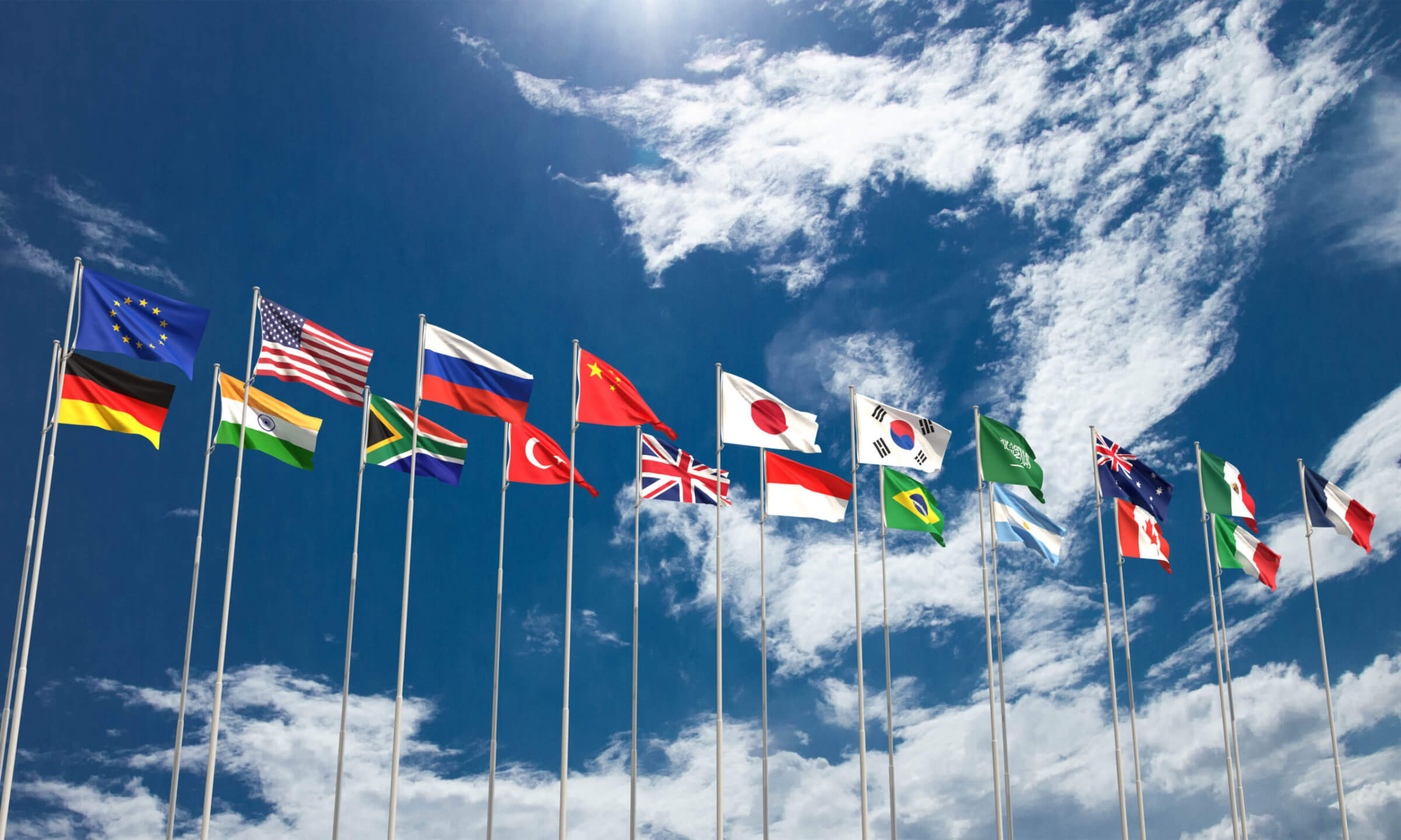 Twenty flags on flagpoles, overlaid over a bright blue sky with a few clouds.