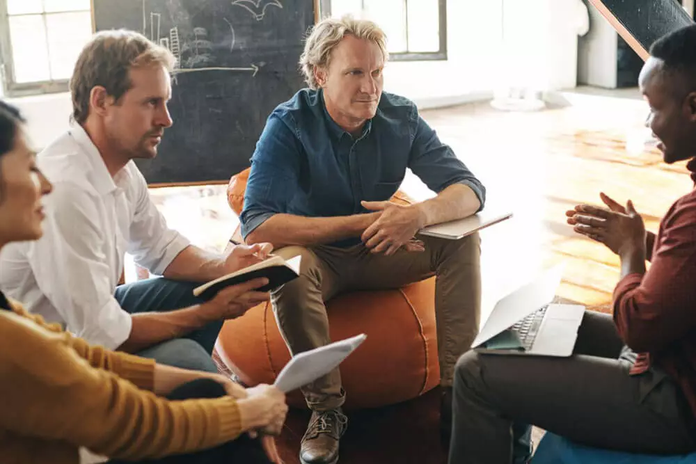 A group of people sitting around a table in a conference room