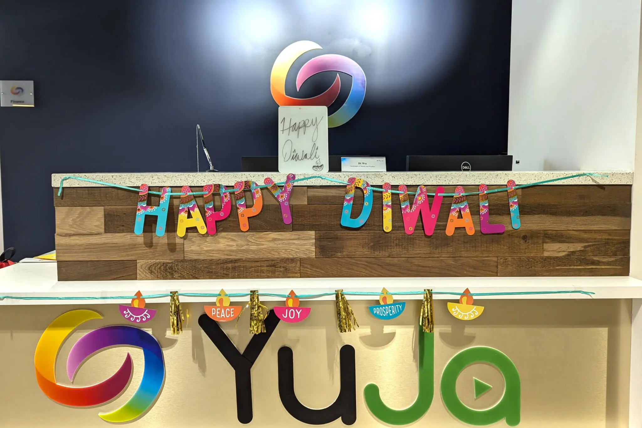 A vibrant Happy Diwali sign hangs on the wall, enhancing YuJa's office festive decorations for the celebration.
