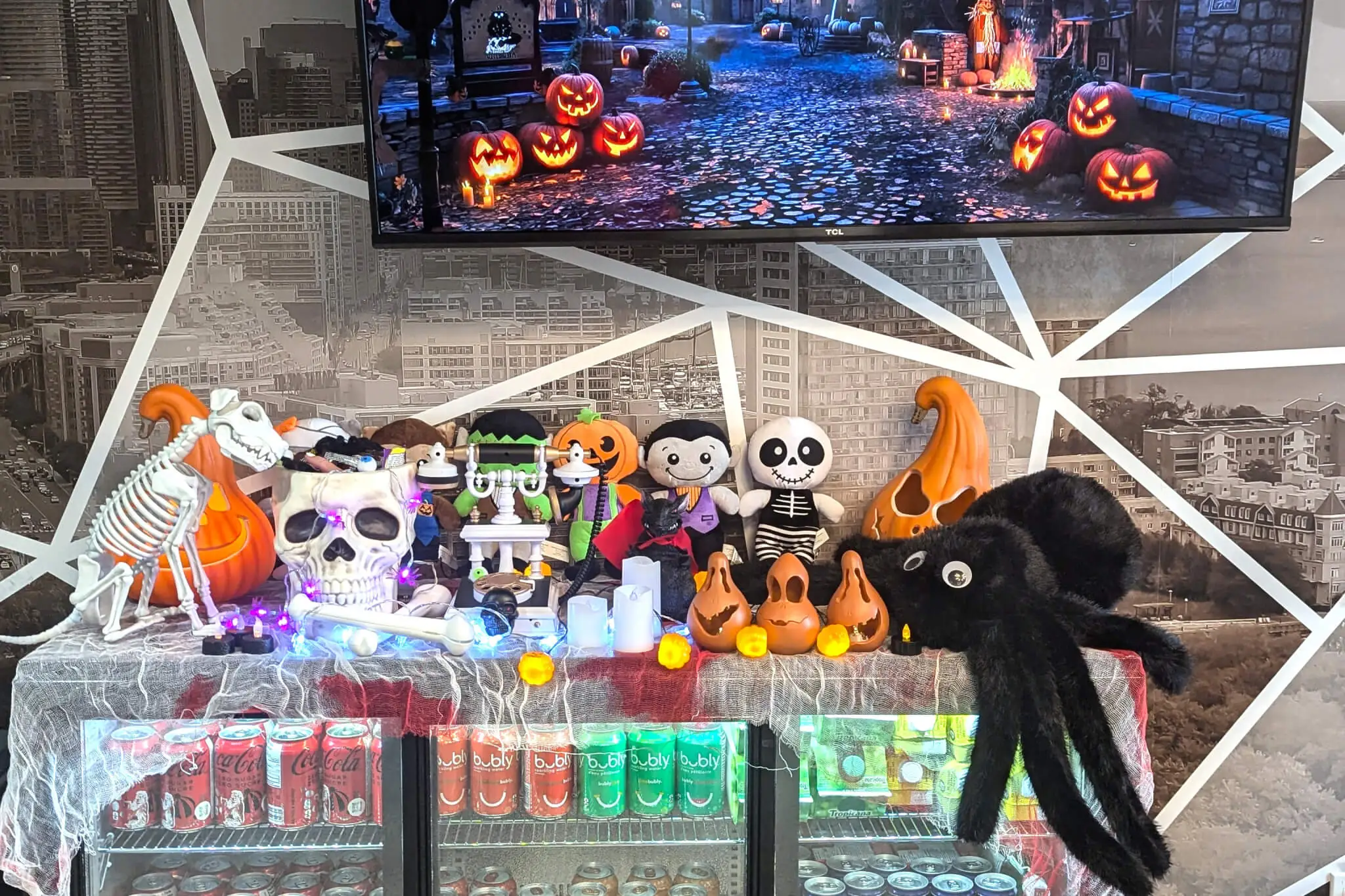 A Halloween-themed bar in YuJa's office, featuring festive decorations and a TV displaying seasonal imagery.