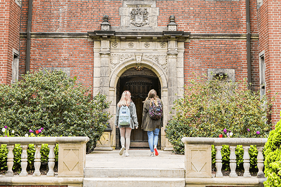 Two students walking uo to a building at Chatham University.