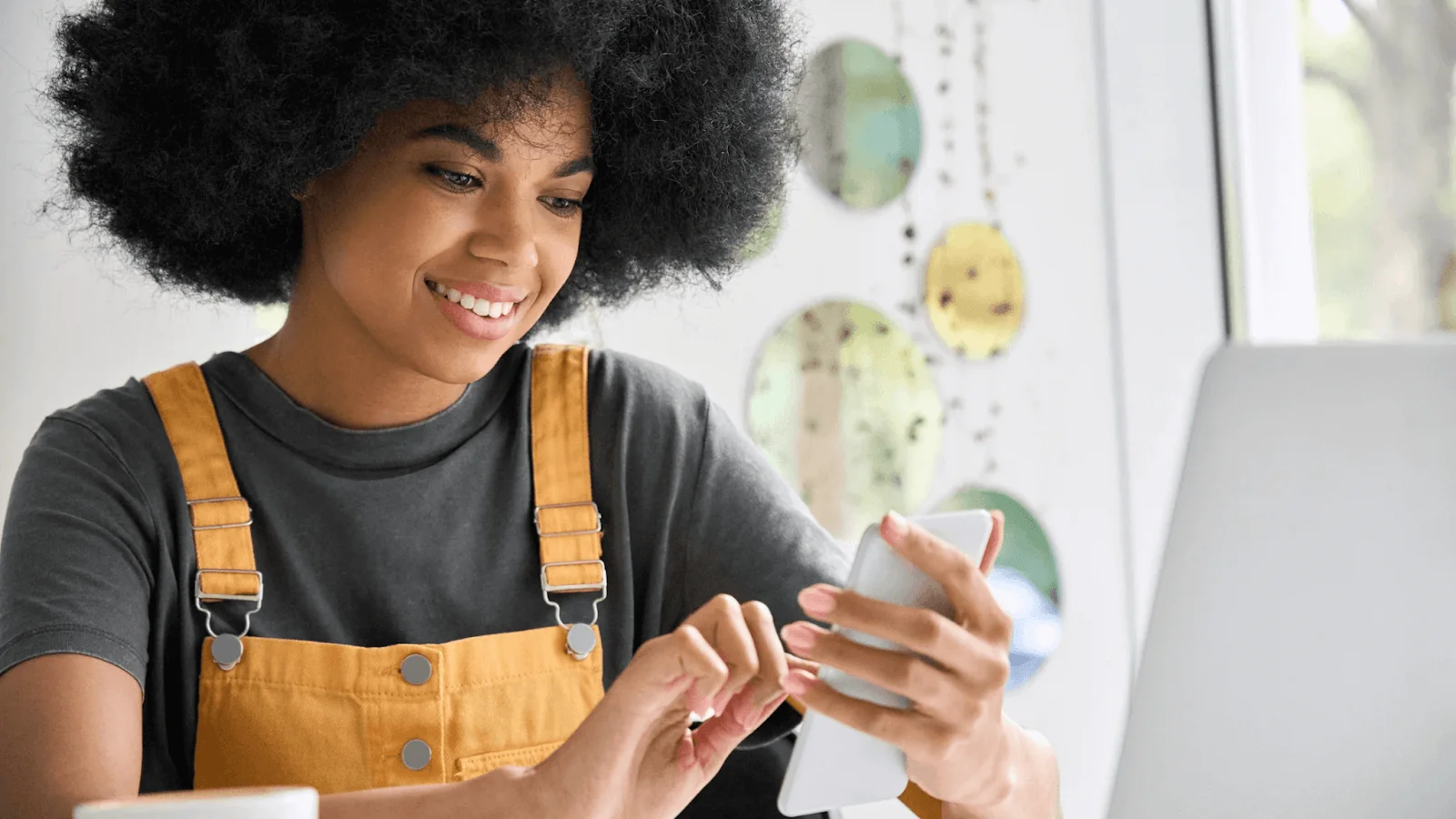 A woman with afro hair using her phone to browse the internet.