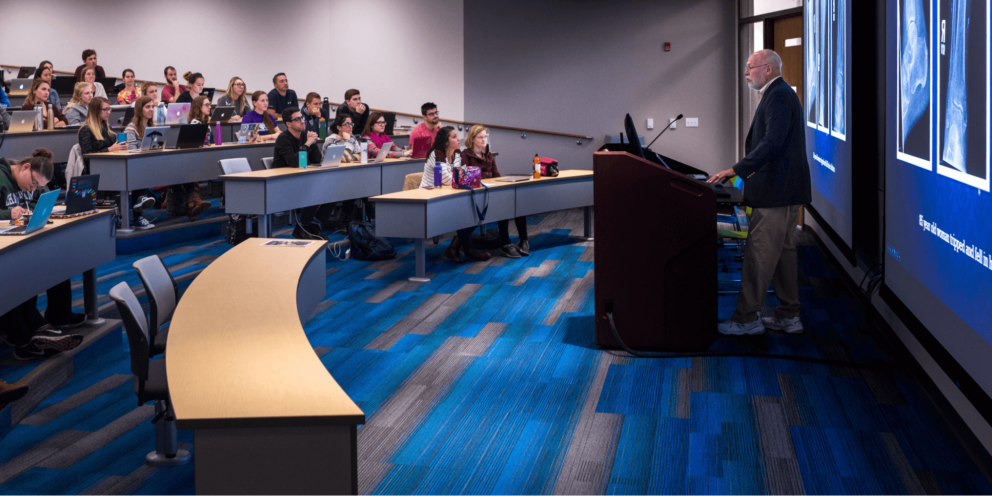 A professor at Chatham University speaking to students in a lecture hall.