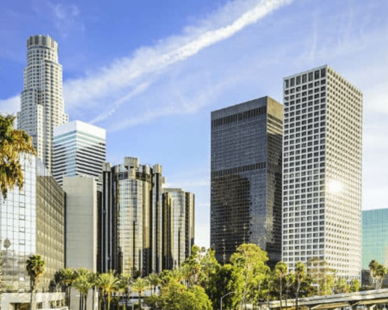 Los Angeles skyline at sunset, showcasing iconic buildings and city lights.