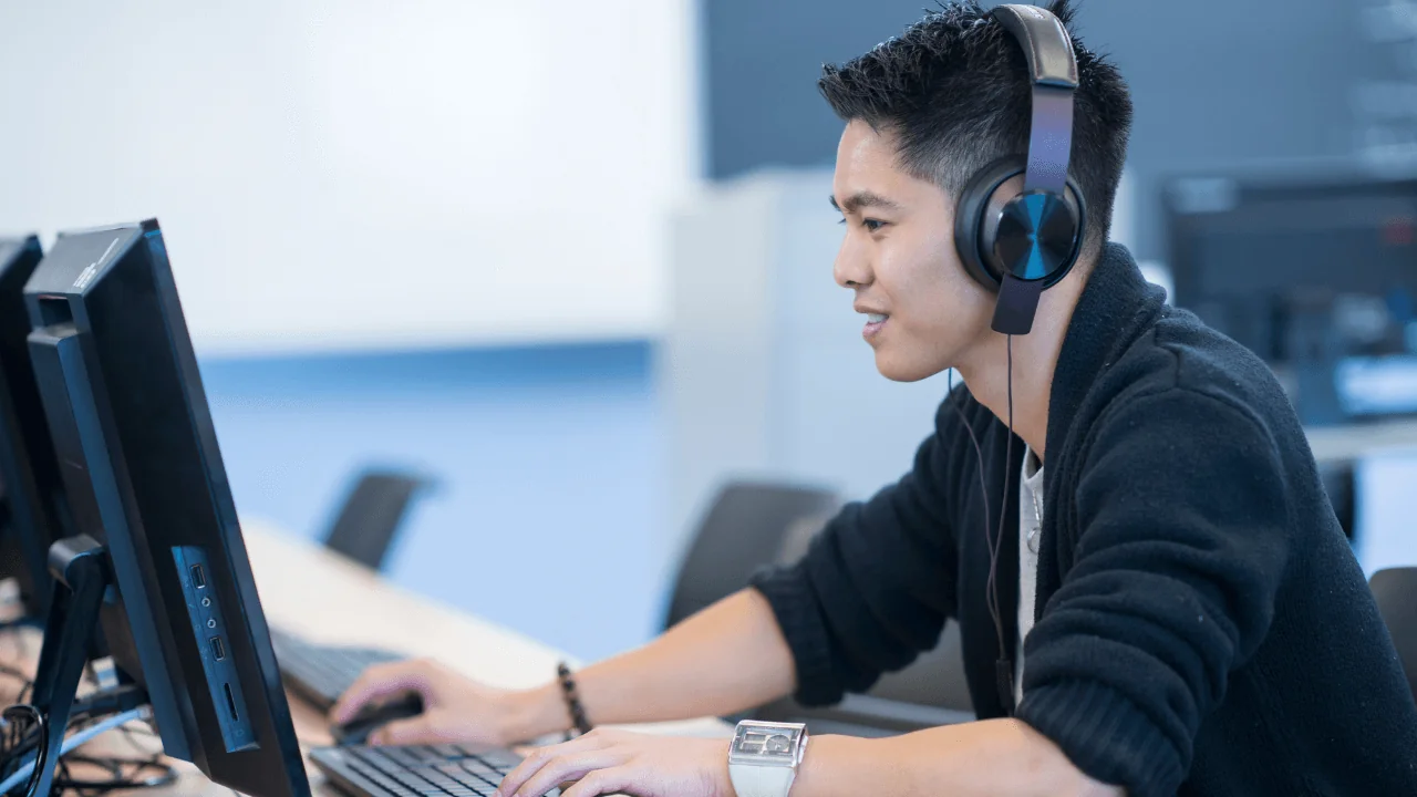 A college student taking an exam with headphones on