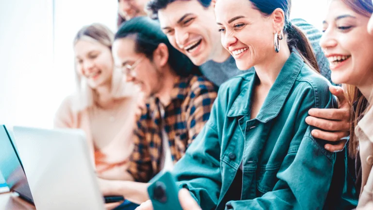 Students looking at a laptop with excitement