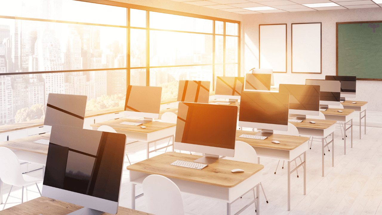 A classroom with large windows and computers at desks