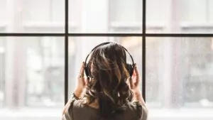 A woman wearing headphones, enjoying music.
