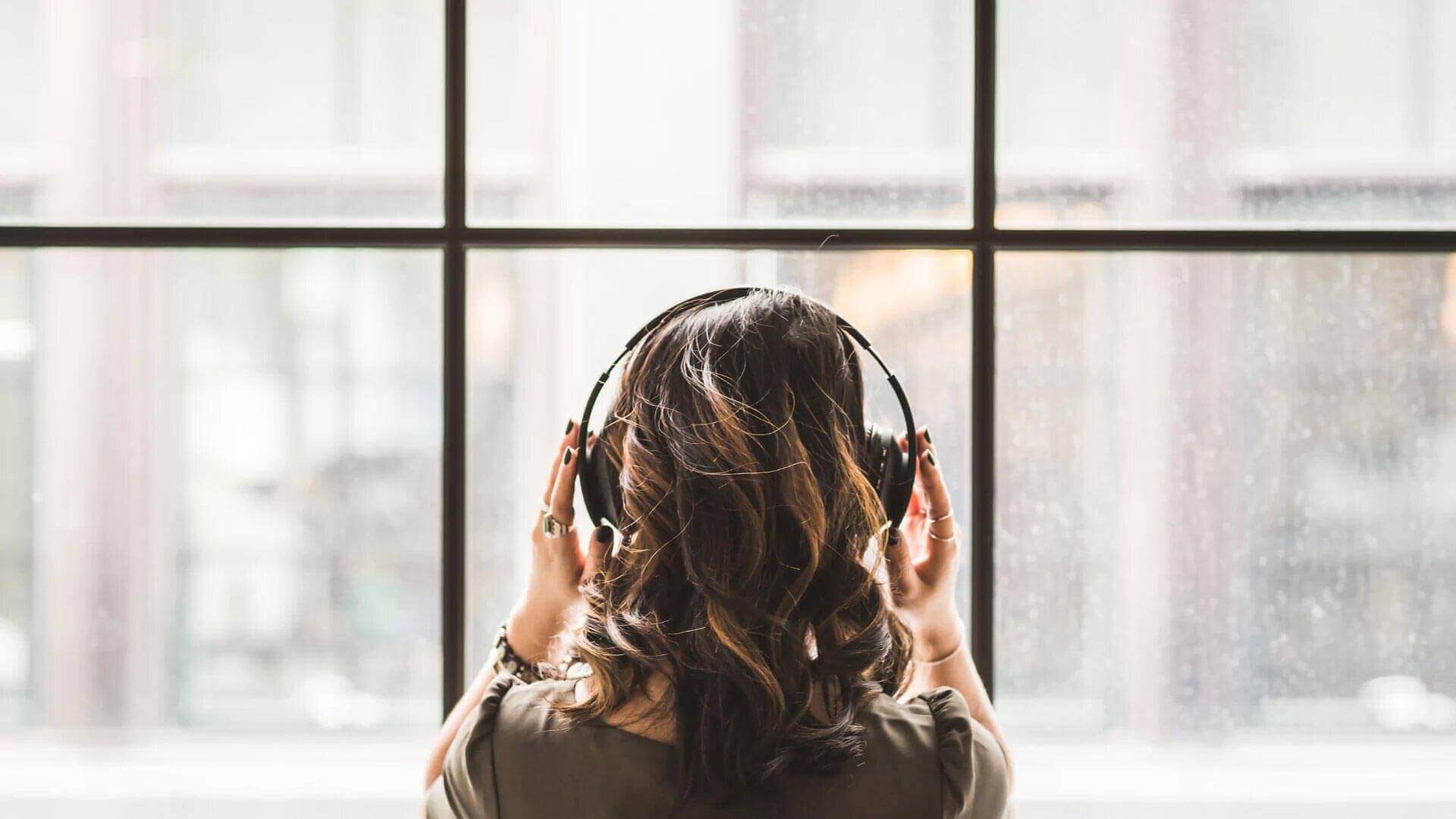 A woman wearing headphones, enjoying music.
