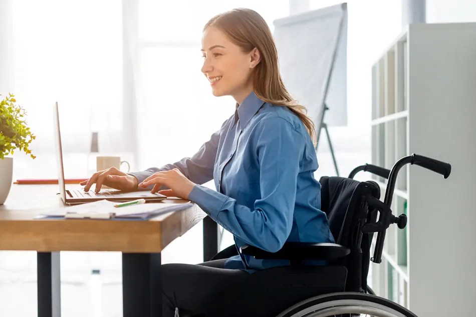 Person in a wheelchair using a laptop computer.