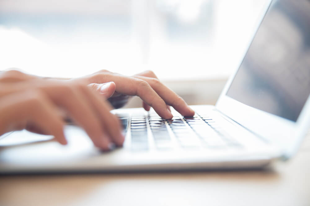 Picture of hands on a laptop keyboard