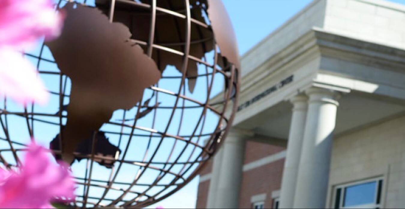 Metal globe in front of Belhaven University building.