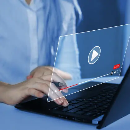 A manu using a computer with a video player overlay.